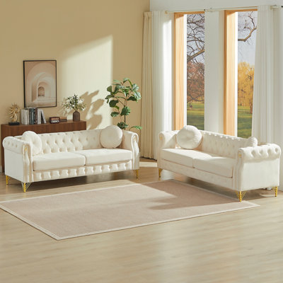 Velvet Chesterfield Sofa With Two Round Pillows, Featuring Copper Stud Detailing And Tufted Button Accents, With Metal Legs. Loop Design Allows For Hanging Cartoon Ornaments.