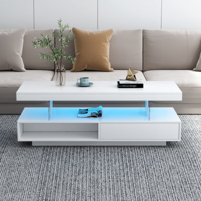 Table centrale à DEL blanche avec tiroirs: 2 espaces de rangement, 16 lumières colorées, 6 niveaux de luminosité et une surface de rangement pour le café dans le salon: blanc. , Luminosité variable. Tiroirs spacieux et tablettes de présentation.