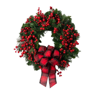Mélange de baies rouges, une couronne de Noël avec un arc à carreaux rouges à la porte d'entrée