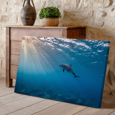 Canvas A Graceful Dolphin Swims Effortlessly In A Crystal Clear Ocean Wall Art Illuminated By Radiant Beams Of Sunlight Filtering Down Canvas Wall Art