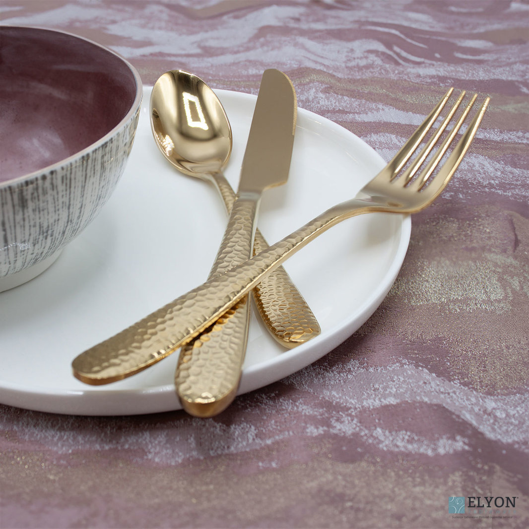 Elyon Carroll Hammered flatware pieces displayed on top of some dinnerware