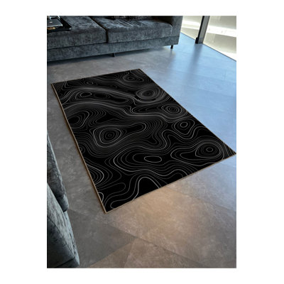 Tapis décoratif moderne noir à motif abstrait en spirale ondulée