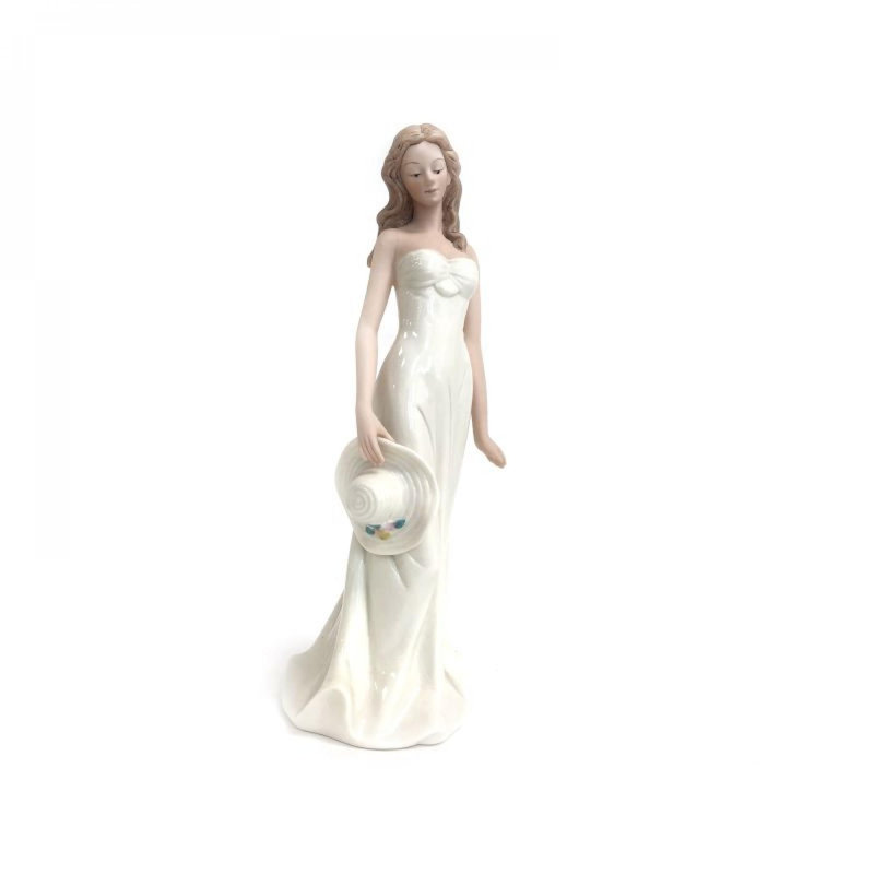 Figurine Dame en blanc tenant un chapeau