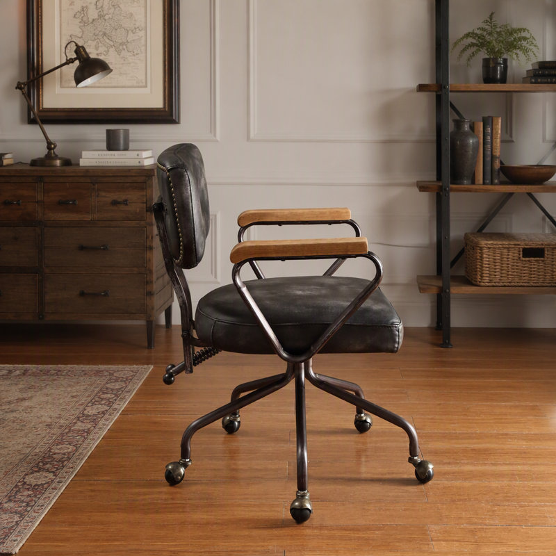 Fauteuil de bureau pivotant vintage en similicuir, orné de clous décoratifs, avec accoudoirs en bois et piètement en métal, sans relevage.