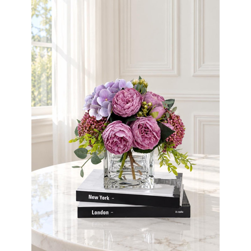 Centre de table en faux pivoines et hortensias roses dans un vase en verre
