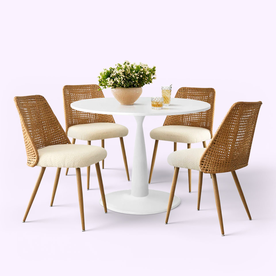 Table ronde blanche avec quatre chaises en osier.