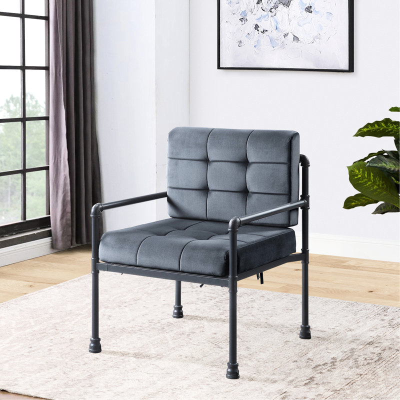 Chaise grise industrielle aux lignes épurées et coussins en tissu à motif géométrique, dossier souple