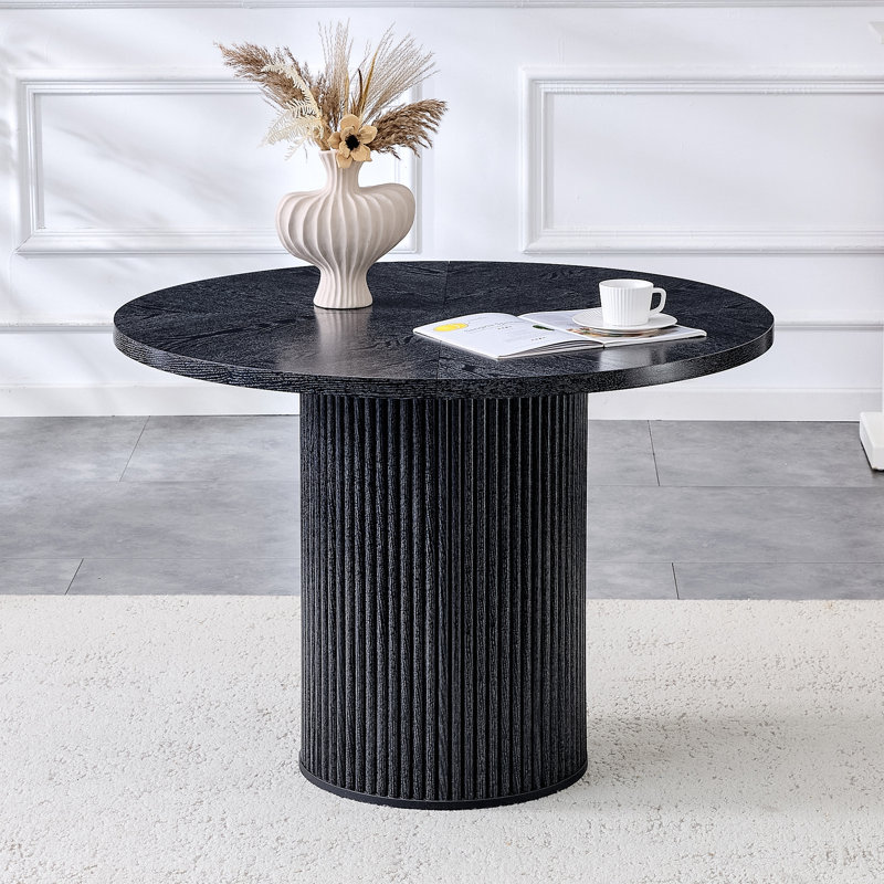 Une table de salle à manger circulaire épissée moderne d'un diamètre de 42 pouces, présentant des textures de couleur de bois noir en forme d'éventail en diagonale, interprétant l'esthétique et la fonctionnalité de la maison.