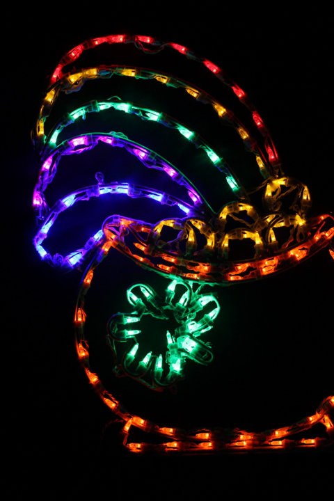 Multi-colored LED light display shaped like a rainbow against a black background.