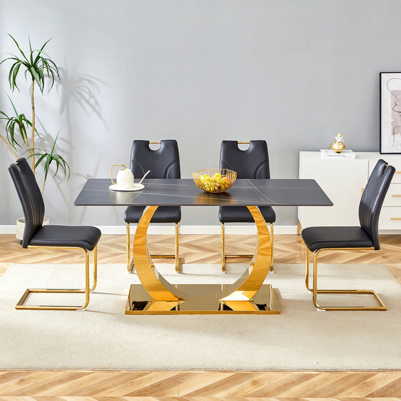Ensemble de table et de chaises. Table de salle à manger en pierre frittée, jumelée à 4 chaises de salle à manger noires de conception unique avec pieds en métal doré. Plateau de table au design noir