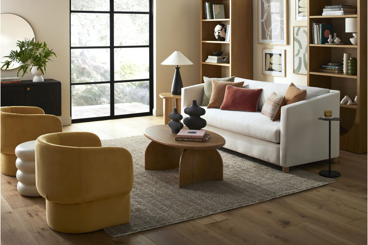 long living room with a sitting area with an area rug sofa coffee table and two accent chairs