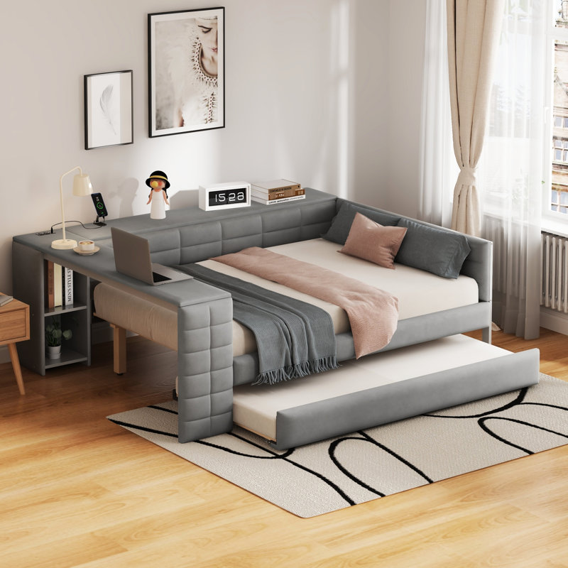 Lit tapissier gris pleine grandeur avec tablettes de rangement, bureau, ports de chargement et lit gigogne simple pour un espace pour plusieurs personnes