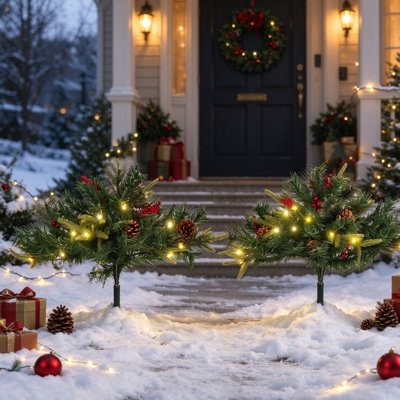 2 arbres de Noël d'extérieur pré-éclairés de 2 pi (ensemble de 2), arbres artificiels sans fil à piles avec 24 lumières DEL blanc chaud, baies rouges et pommes de pin, piquets de trépied pour le porche, l'entrée et l'allée