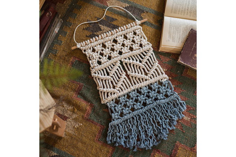 Cream and blue macrame wall hanging.