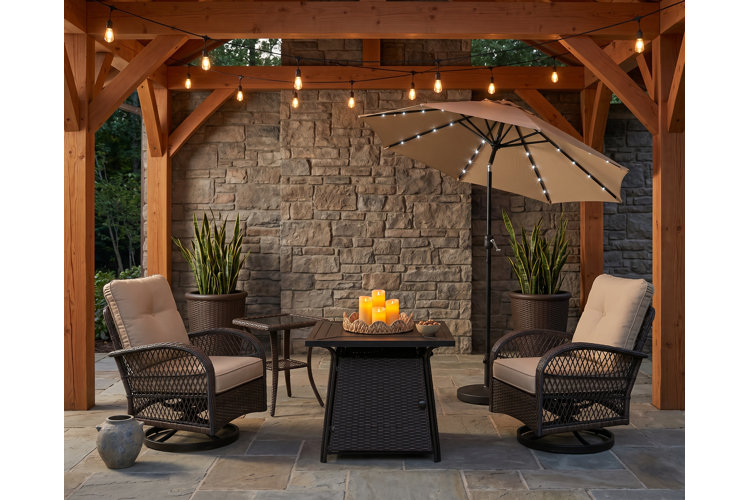 covered patio with pavers, stone walls, and a black wicker conversation set.