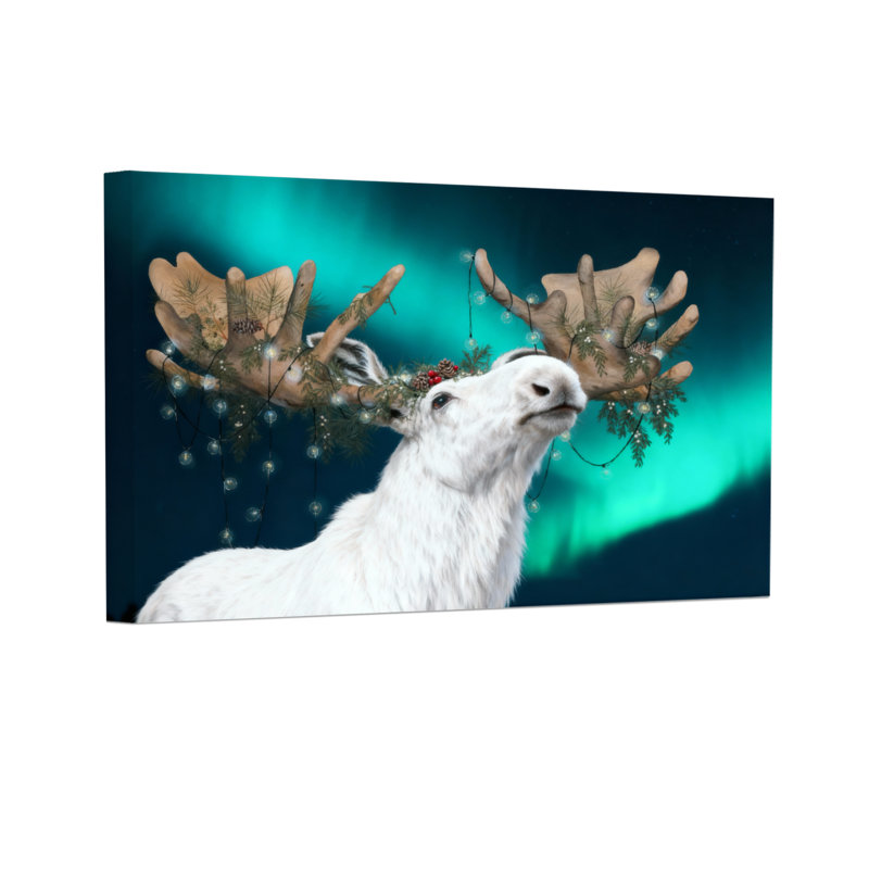 Renne de Noël blanc avec des bois décorés sur fond d'aurore