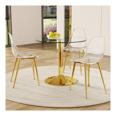 Ensemble de table et de chaises. Une table de salle à manger ronde en verre trempé transparent de 35 po - Support et base en métal doré. Assorti de 3 chaises de salle à manger en plastique transparent, de pieds en métal doré et d'un coussin de doss