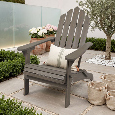 Chaise d'extérieur Adirondack pliable en bois d'acacia avec dossier à lattes et larges accoudoirs, idéale pour la terrasse, le patio ou le bord de la piscine.