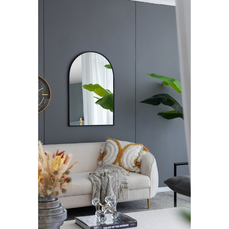 Miroir mural avec cadre en métal arqué noir, convenant à un décor moderne pour le salon