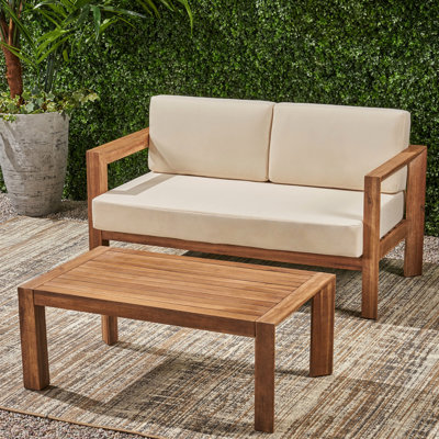 Table basse d'extérieur en bois avec coussins et dossier à lattes ouvertes, beige et brun, rembourrage à l'eau, assise arrière,