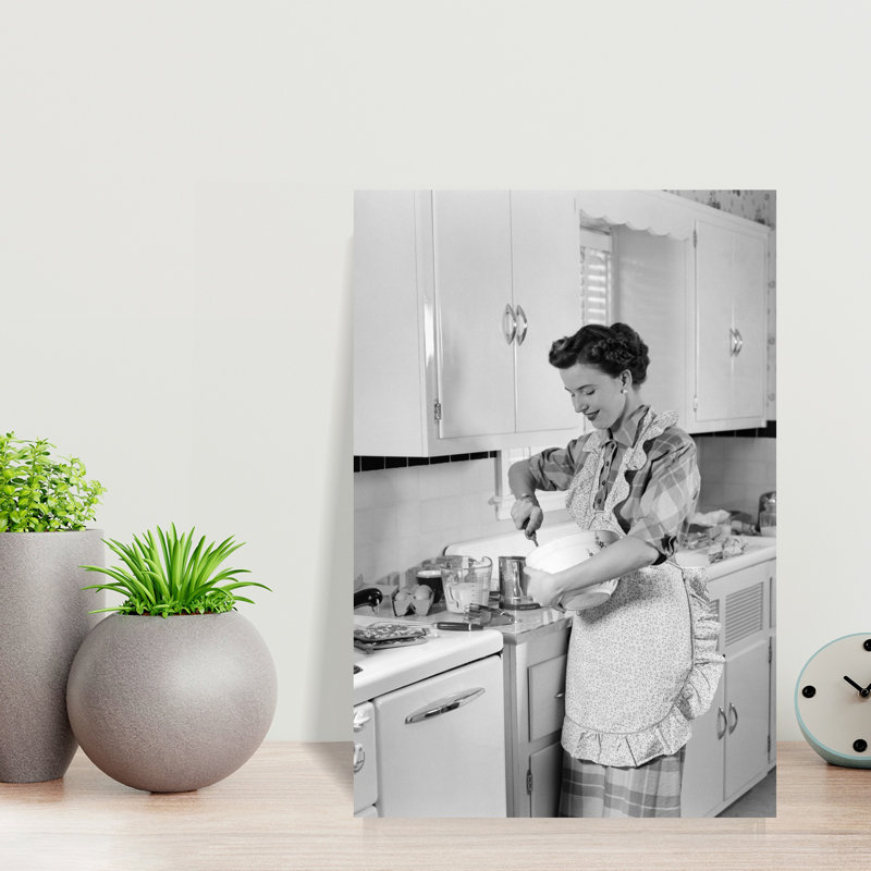 1950s WOMAN HOUSEWIFE IN KITCHEN APRON MIXING BAKING INGREDIENTS IN BOWL by H. Armstrong Roberts - Wrapped Canvas Print