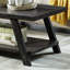 Table basse contemporaine en bois imitation anthracite avec tablette, rangement supplémentaire et pieds à angle large. Un design élégant et un gain d'espace appréciable.