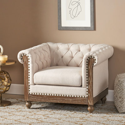 Fauteuil club inspiré du style classique, avec revêtement lisse, capitonnage profond, pieds tournés, tissu beige, hauteur 72,5 cm, largeur 98,5 cm