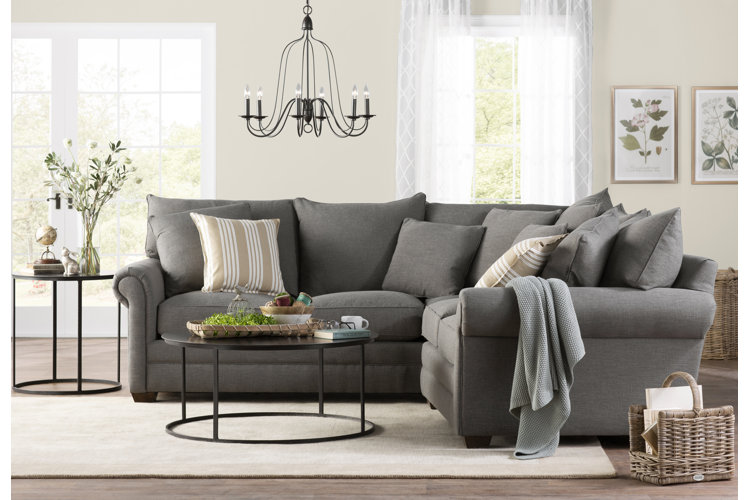 gray sectional covered in cozy accent pillows and a throw blanket