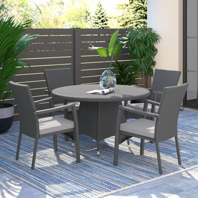 Arturas 4 - Person Wicker Patio Dining Set with Round Table , Cushions Included