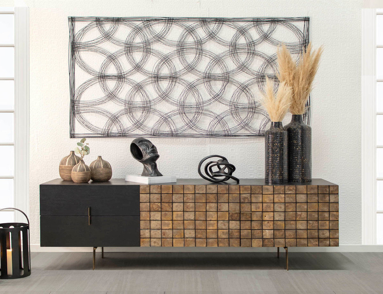 black and brown sideboard with decorative accessories placed on it and black wall decor