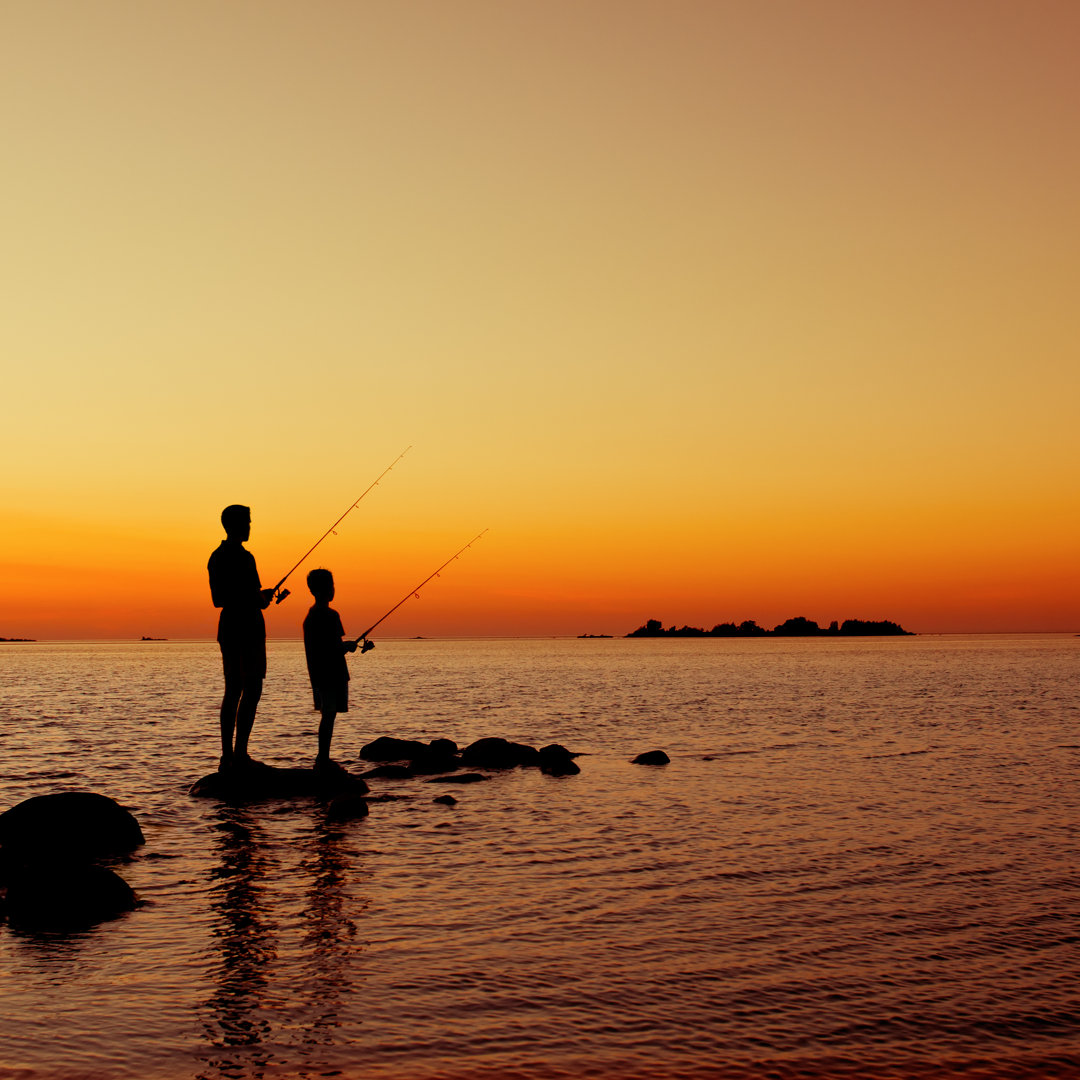 Jungen fischen bei Sonnenuntergang von Alpamayo - Leinwandbild