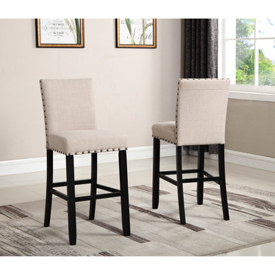 Tabourets de bar en tissu brun clair, structure en bois franc et garniture cloutée. Revêtement en lin et en coton. H 44 po, hauteur de siège de 30 po. Foncé. 16 po x 23 po 2 tabourets. Bois franc, hauteur 30 po, H 44 po. Finition.