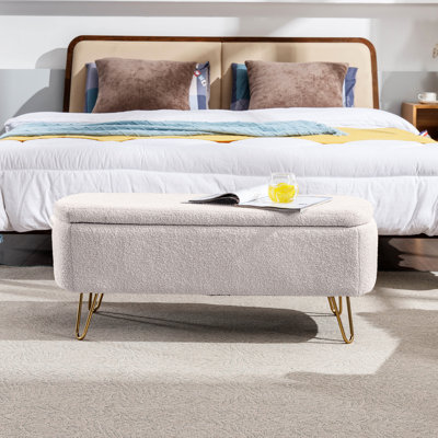 Banc de rangement blanc avec pieds dorés et fonction pratique pour le salon