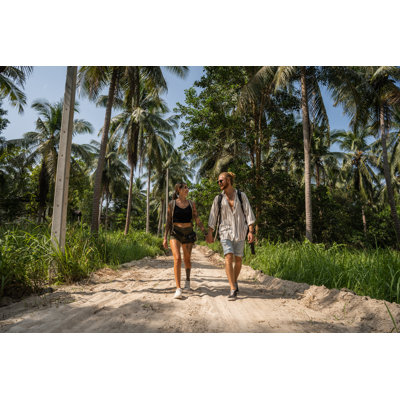 Caucasian couple walking through rainforest Wall Art on Canvas