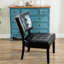 Fauteuil surdimensionné en similicuir noir avec un capitonnage délicat dans un coin salon confortable