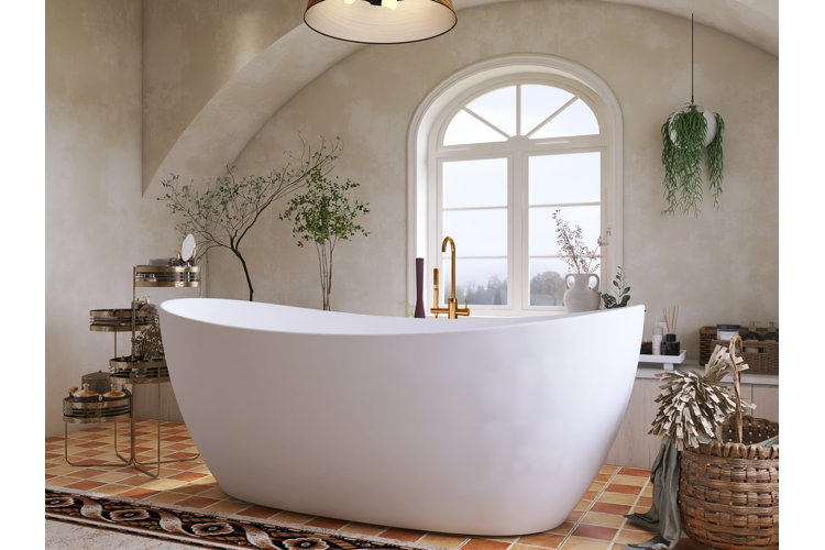 luxury bathroom with teracotta tile and larger white freestanding tub. woven planter, hanging planter, and freestanding bathtub faucet in gold
