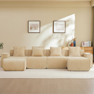 Canapé modulaire 4 places sans ossature, finition passepoilée en velours camel, livré monté, coussins décoratifs et 2 poufs inclus pour un intérieur élégant et épuré. Finition passepoilée en forme de U. Mobilité et confort absolu.