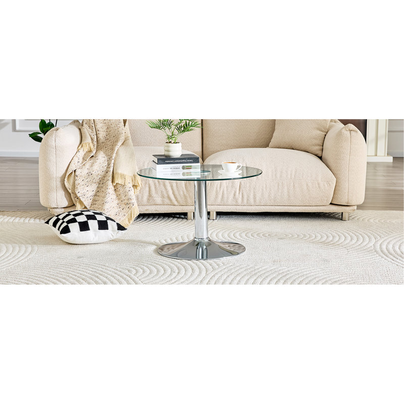 Table basse ronde en verre trempé de 27,5 pouces de diamètre. 17,7 pouces de haut, soutenu par une base en métal argenté, avec un bord de luxe léger.