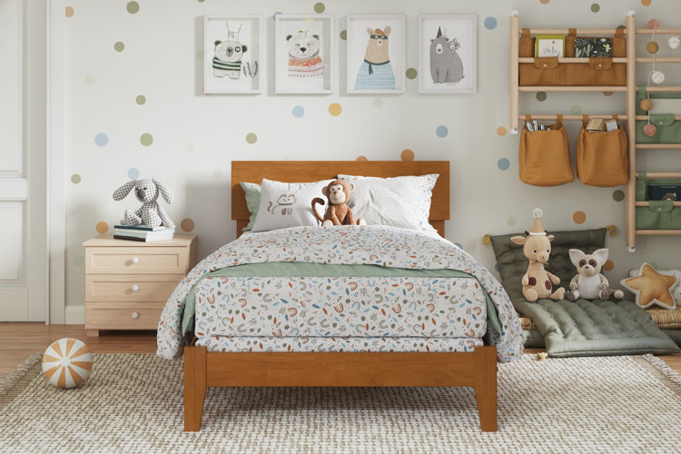 kids bedroom with wooden bed, polka-dot wall, stuffed animals, and neutral woven area rug