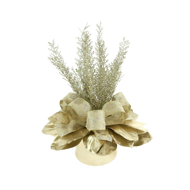 Holiday Arrangement With Magnolia Leaves, Sparkly Branches And Bows In A Glass Vase