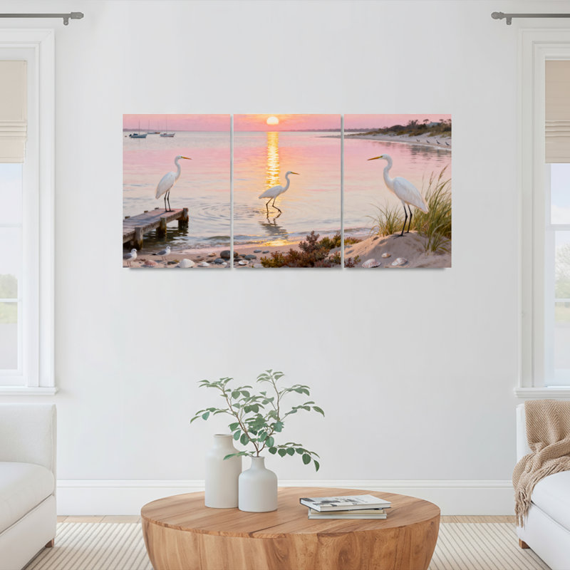 Ensemble de 3 toiles murales montées sur châssis représentant un coucher de soleil sur une plage avec un héron
