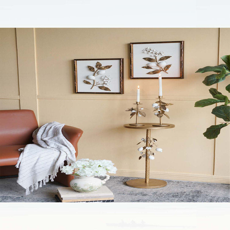 Luxueuse table d'appoint ronde en fer avec accents floraux dorés et blancs, base en ciment robuste pour une décoration intérieure élégante