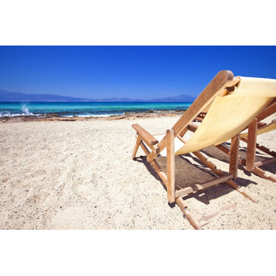 Sun Chairs On Sandy Beach by Mbbirdy - Wrapped Canvas Print