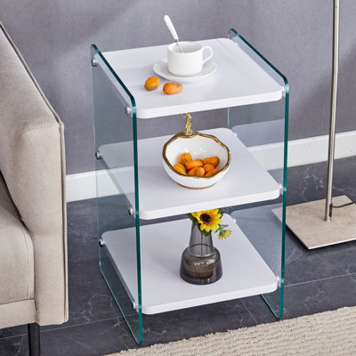 Trois niveaux de tables de chevet. La surface du panneau est en panneau de fibres à densité moyenne avec des autocollants blancs et les deux côtés sont en verre trempé transparent. La conception est simple et généreuse, avec fonction de rangement. 