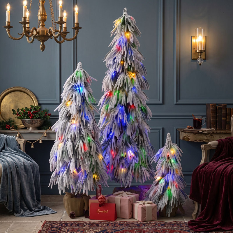 Ensemble de 3 sapins de Noël artificiels pré-illuminés, recouverts de neige floquée et de lumières DEL multicolores.