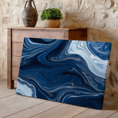 La toile crée un design abstrait avec une texture de marbre fluide dans un art mural bleu marine foncé et des tons de blanc doux avec un art mural sur toile tourbillonnant