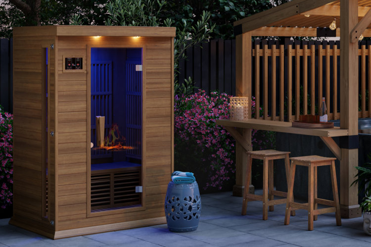 wood sauna on a patio beside a hot tub beneath a wood pergola