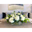 Arrangement floral d'hortensias et de chardons dans un vase en verre rectangulaire