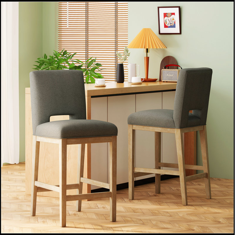 Tabouret de bar moderne rembourré avec base en bois robuste, conçu pour le confort et le style dans les espaces de salle à manger contemporains.