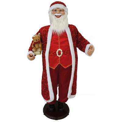 Père Noël dansant en costume rouge à paillettes avec ours en peluche et cadeaux emballés